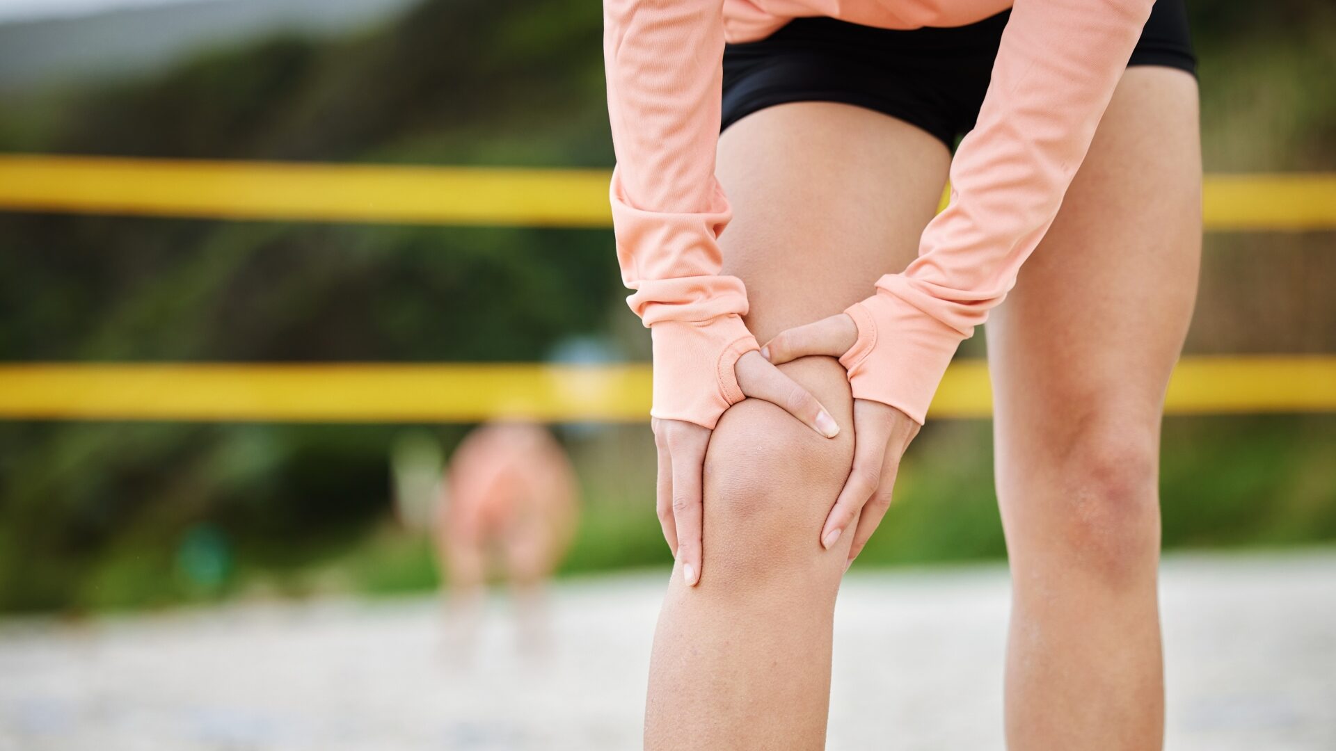 Sportowy ból kolana, dłonie kobiety i kontuzja sportowca na piasku podczas siatkówki plażowej po wypadku sportowym